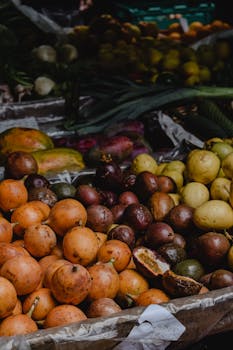 A vibrant display of assorted organic fruits including guavas and passion fruits at a market in Funchal, Madeira.