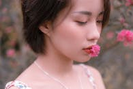 Close-Up Shot of a Woman with a Flower on Her Lips