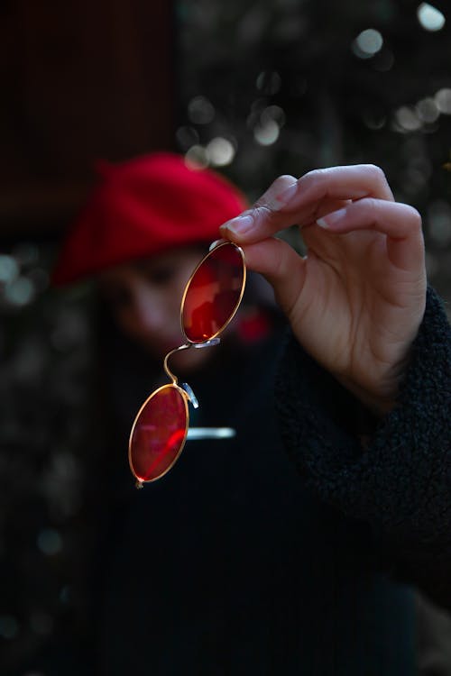 Person Holding Red Sunglasses