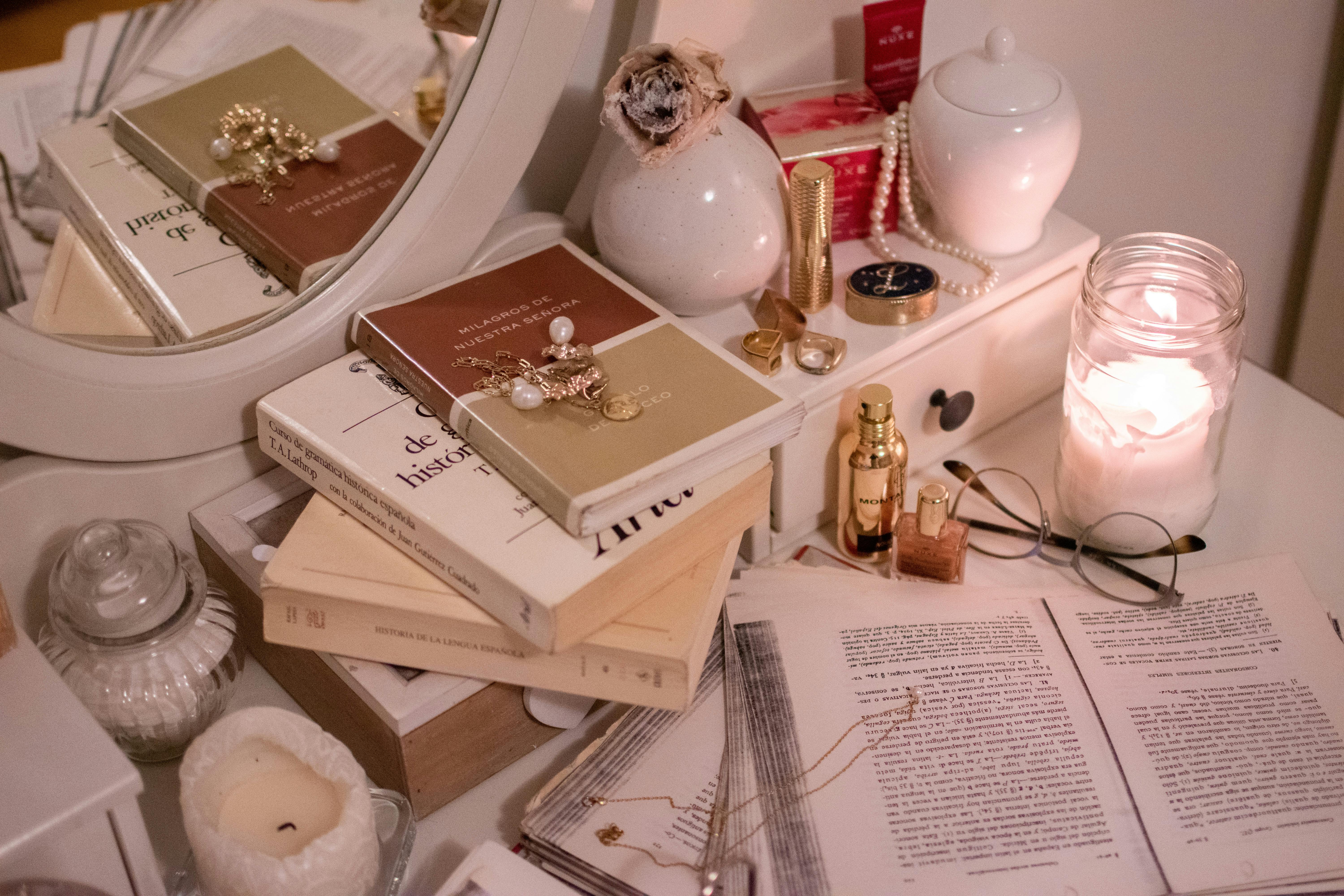 A warm, serene arrangement with books, candle, and decorative objects on a table.