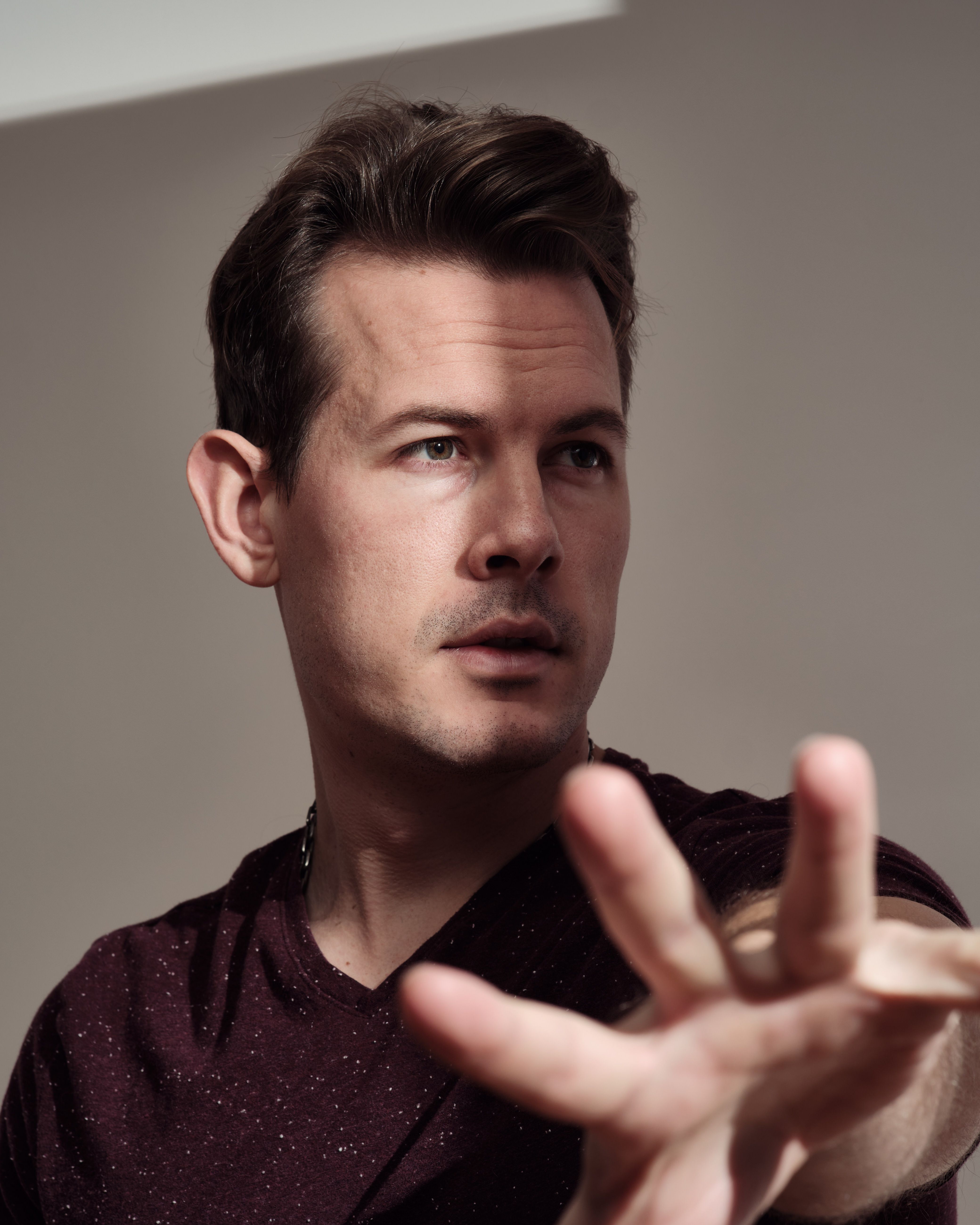 Portrait of a man looking away with a dramatic gesture, highlighting depth and emotion.