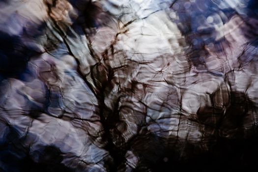 Textured backdrop of creased textile with uneven surface and spots with pleats between shadows