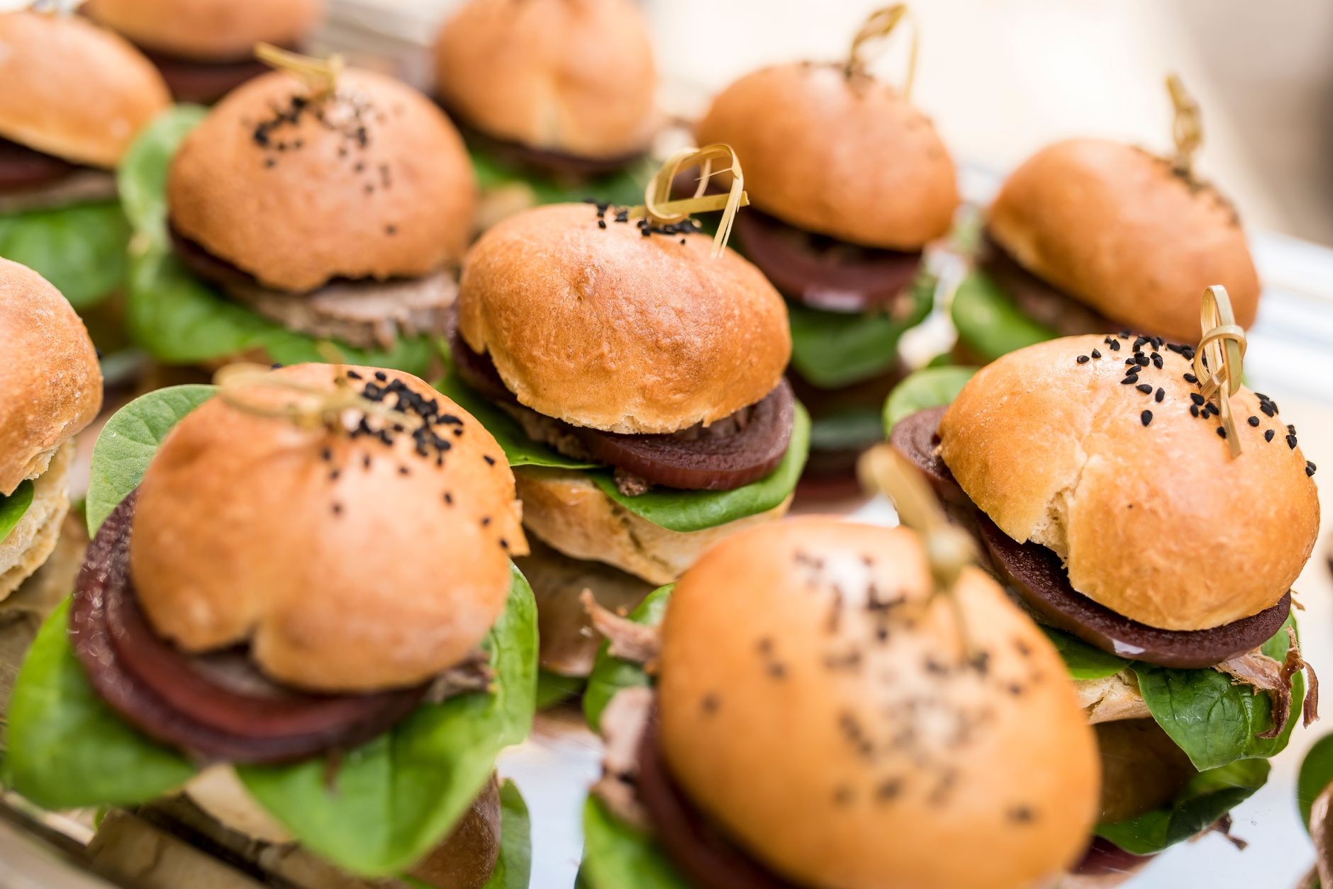 18 Mouthwatering Burger Recipes for Everyone Delicious mini burgers with spinach and beetroot, perfect for parties or events, served on a decorative platter.