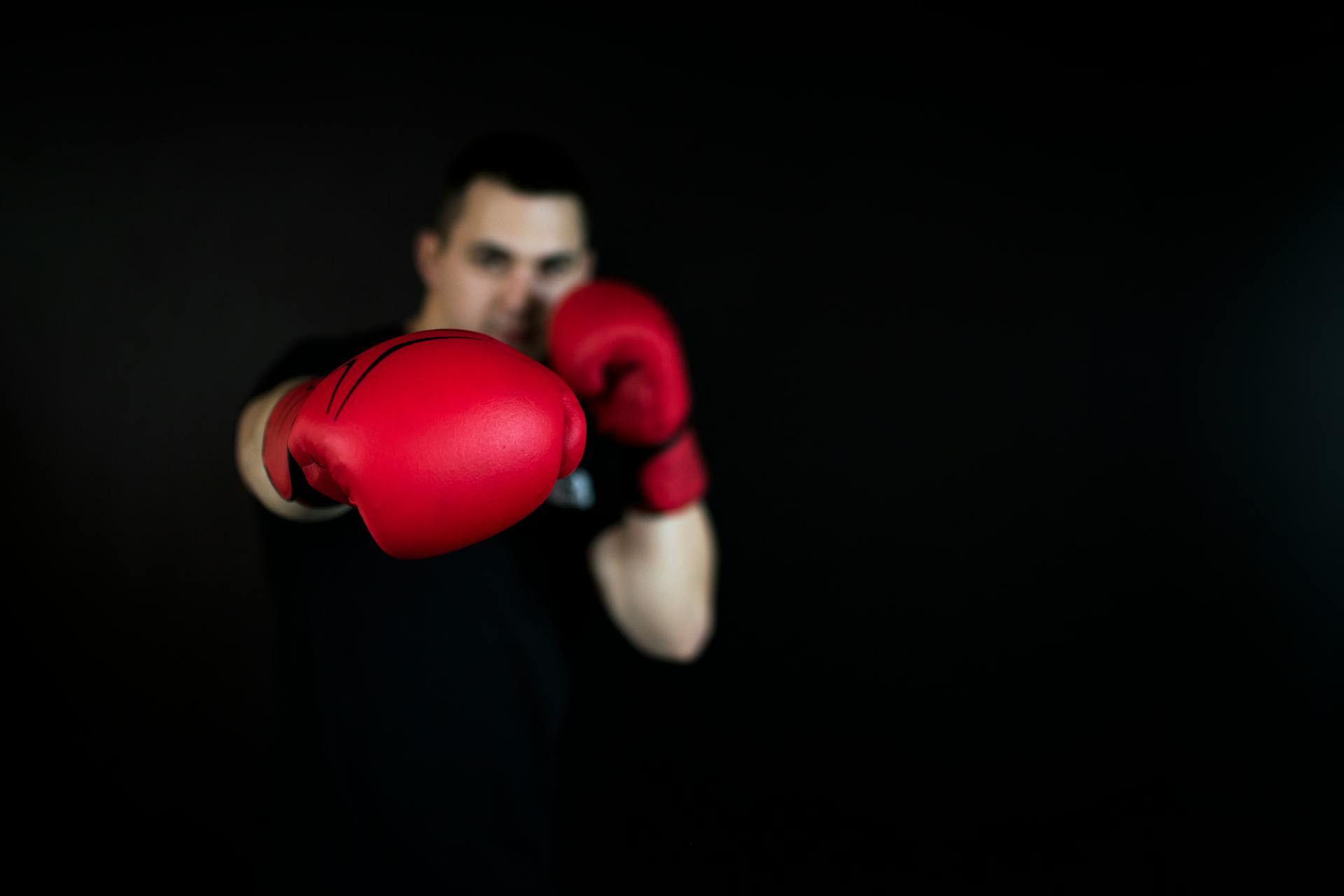 Person in Black Shirt and Red Boxing Gloves