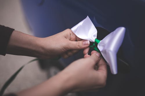 Woman tying a white bow