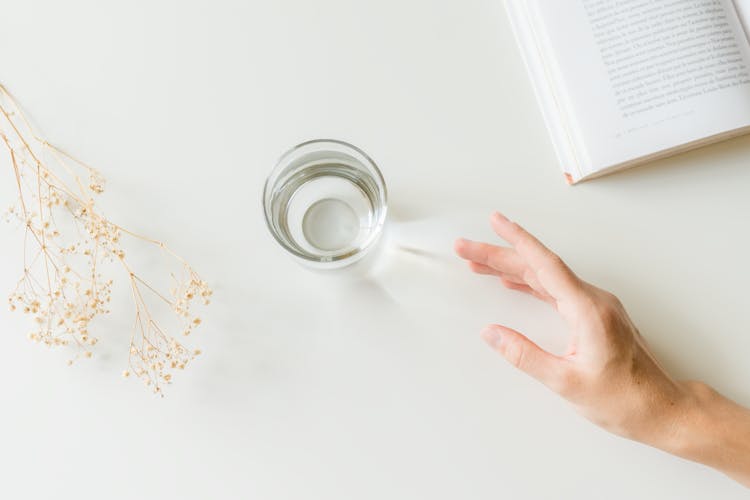 A Glass Of Water On A White Surface 