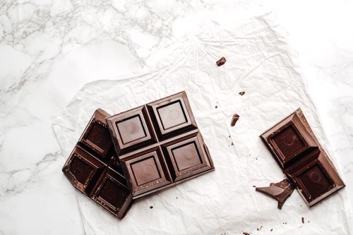 Free Elegant display of dark chocolate bars on a white marble surface. Perfect for dessert lovers. Stock Photo