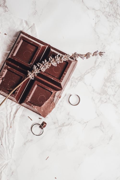 Free Elegantly styled dark chocolate with lavender and rings on marble background. Stock Photo