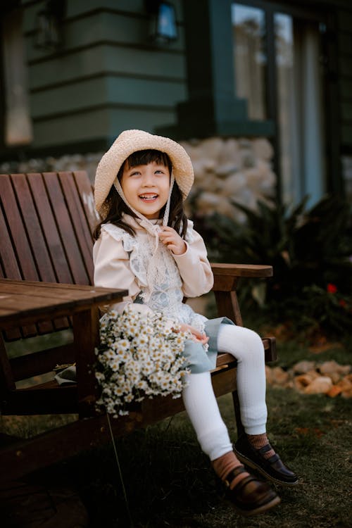 Smiling Asian girl with straw hat on terrace