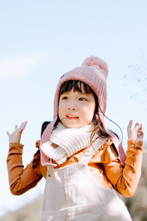 Cheerful Asian girl in hat in nature