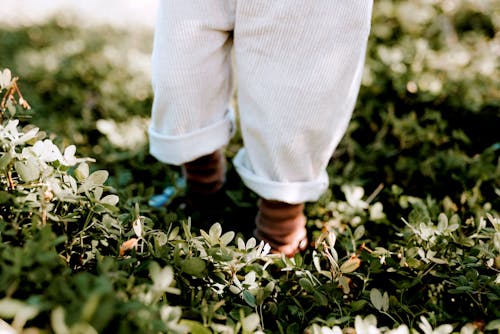 Crop child standing on grass