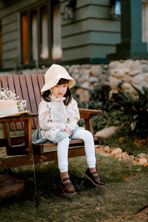 Calm Asian girl sitting on chair in backyard