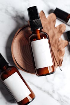 Minimalist skincare product setup with amber bottles on a marble background.