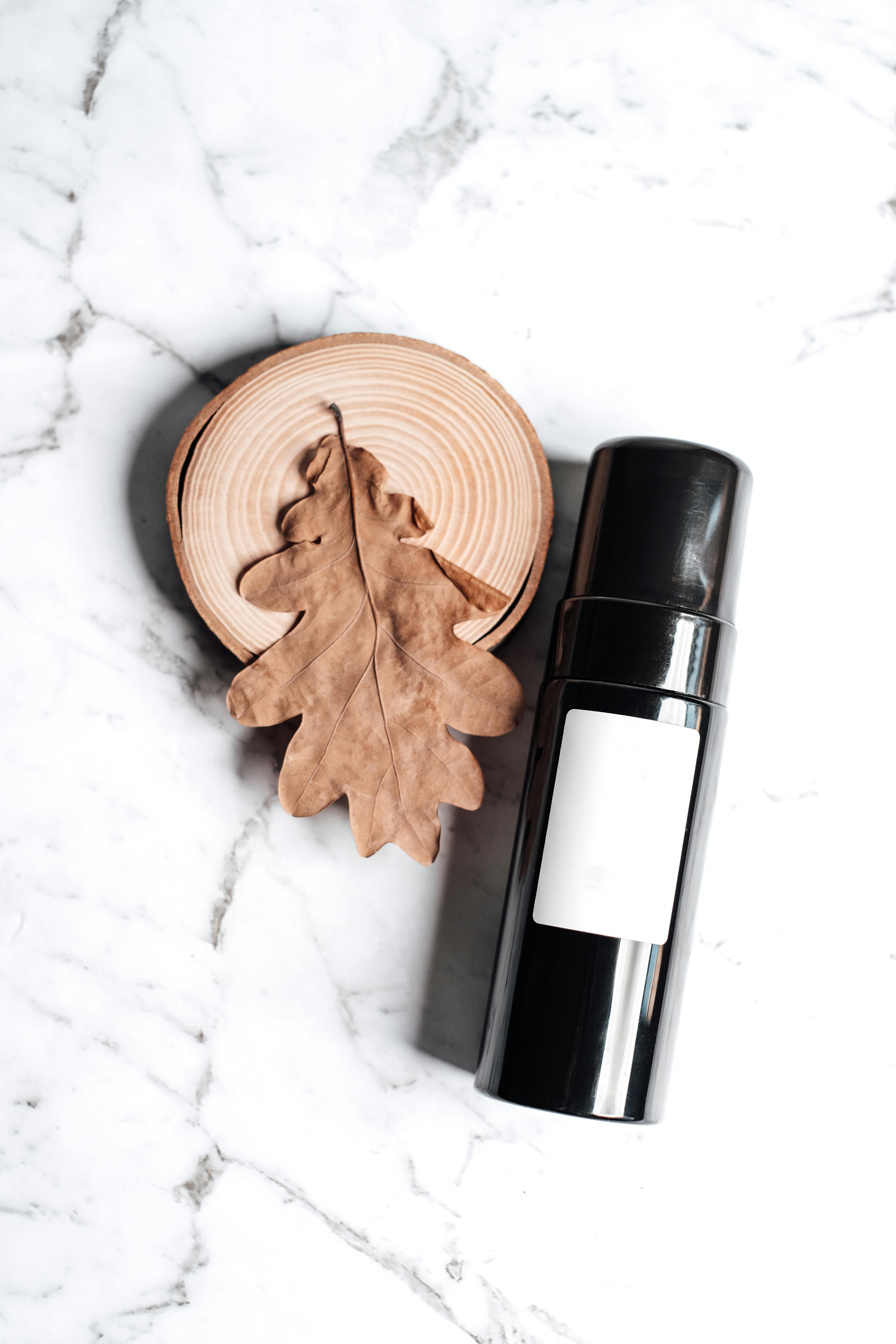 brown leaf and black cylinder shaped bottle