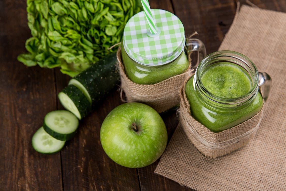 Green Apple Beside of Two Clear Glass Jars