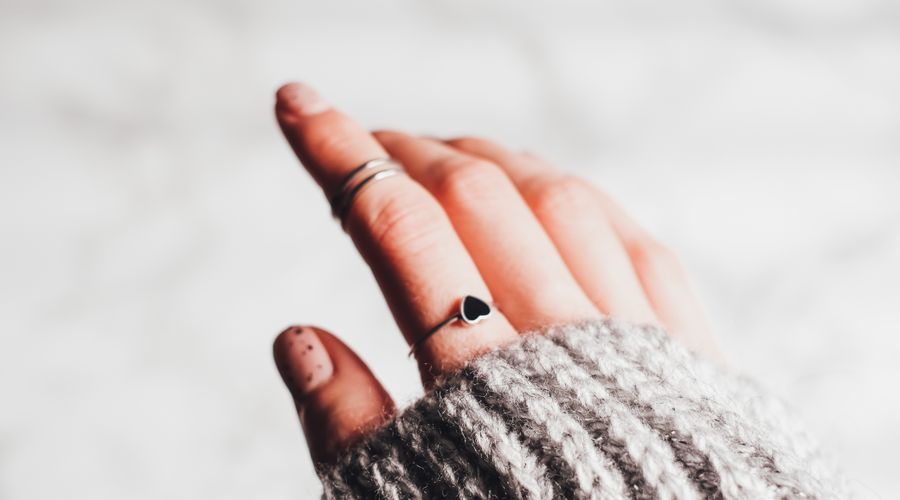 Main portant une bague fine minimaliste en argent