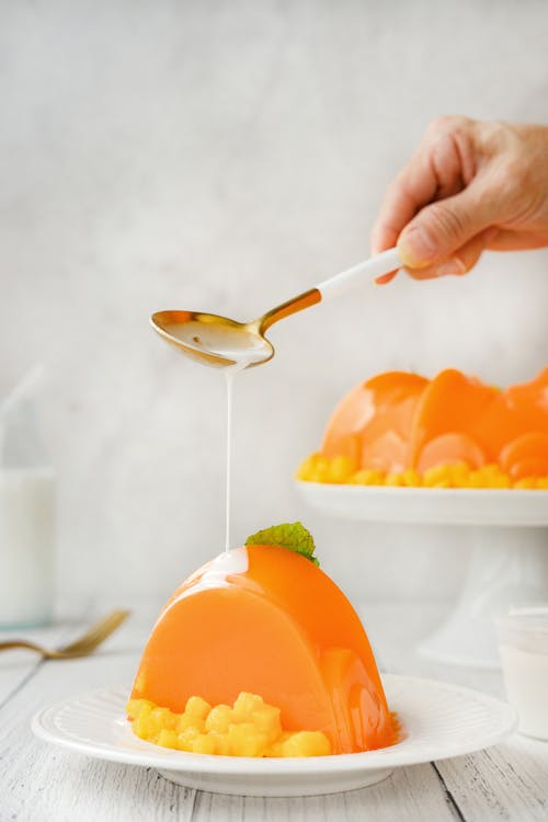 Free Pouring of Cream in a Fruit Mango Jelly  Stock Photo