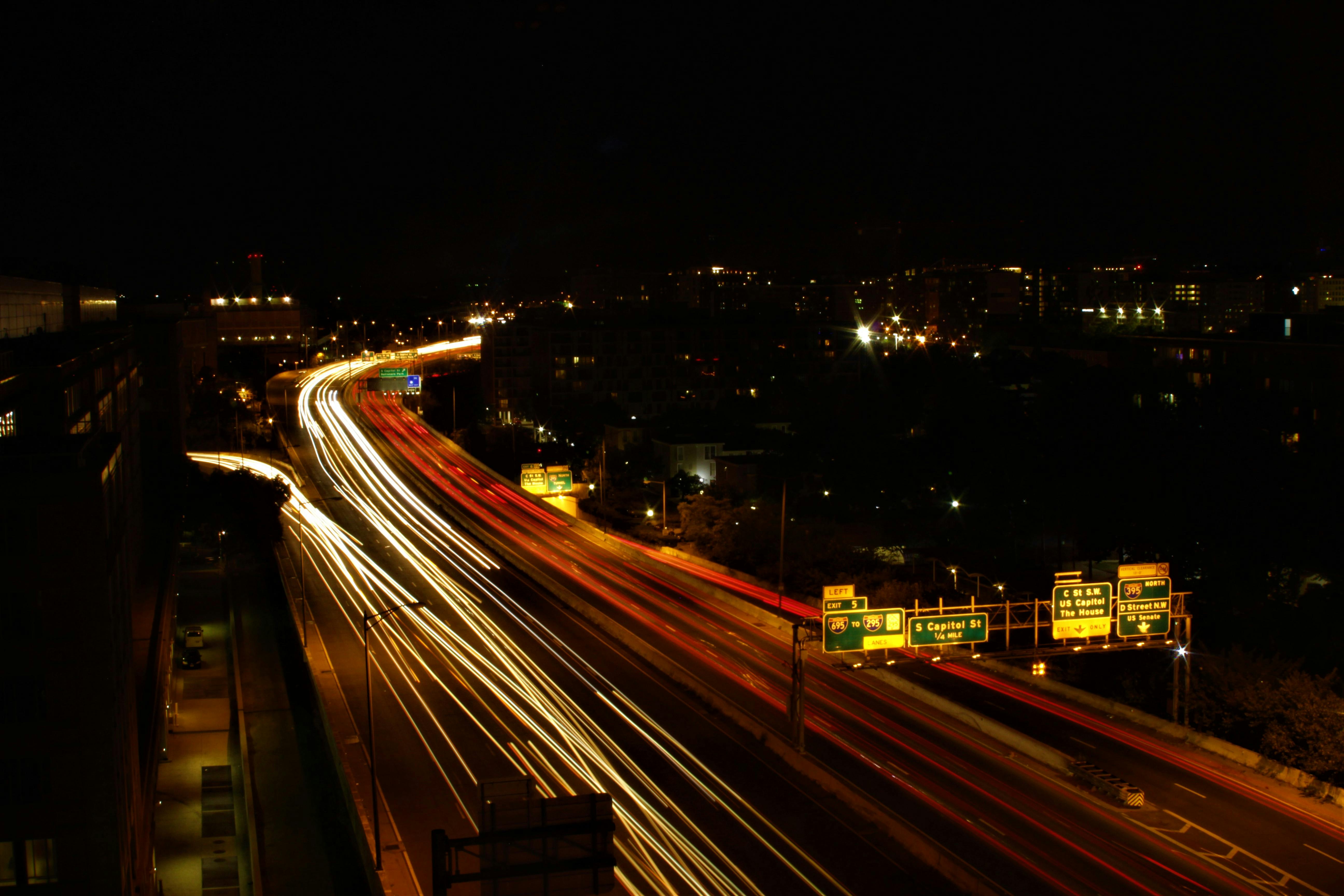 panning photography of vehicles on road at night