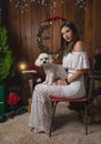 Woman in White Floral Dress Sitting on Red Chair Holding White Dog