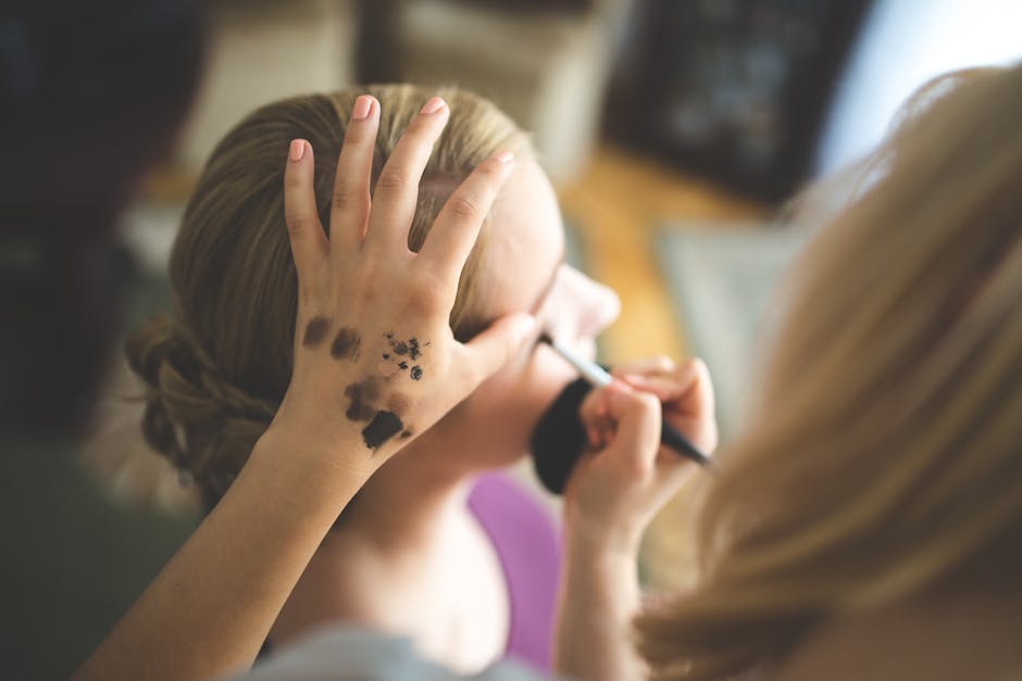 Make up artist applying shadow to a woman