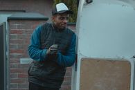 Man in Blue Jacket and Black Pants Holding Black Smartphone