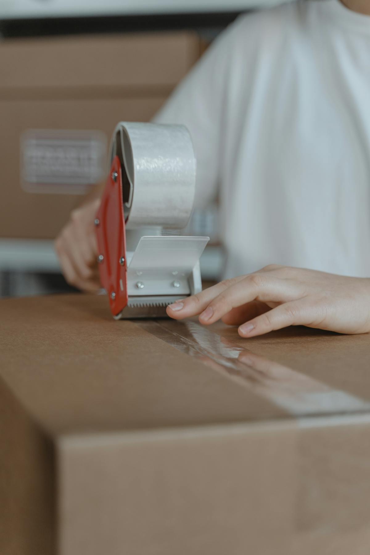 Packing tape dispenser sealing a shipping box