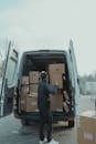Man Putting the Brown Cardboard Boxes Inside the Van