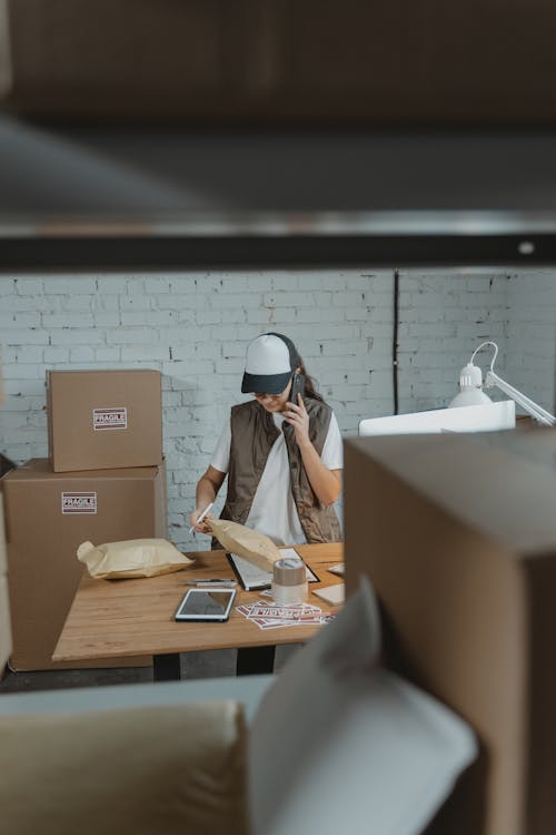 Woman having a Phonecall while looking at a Parcel