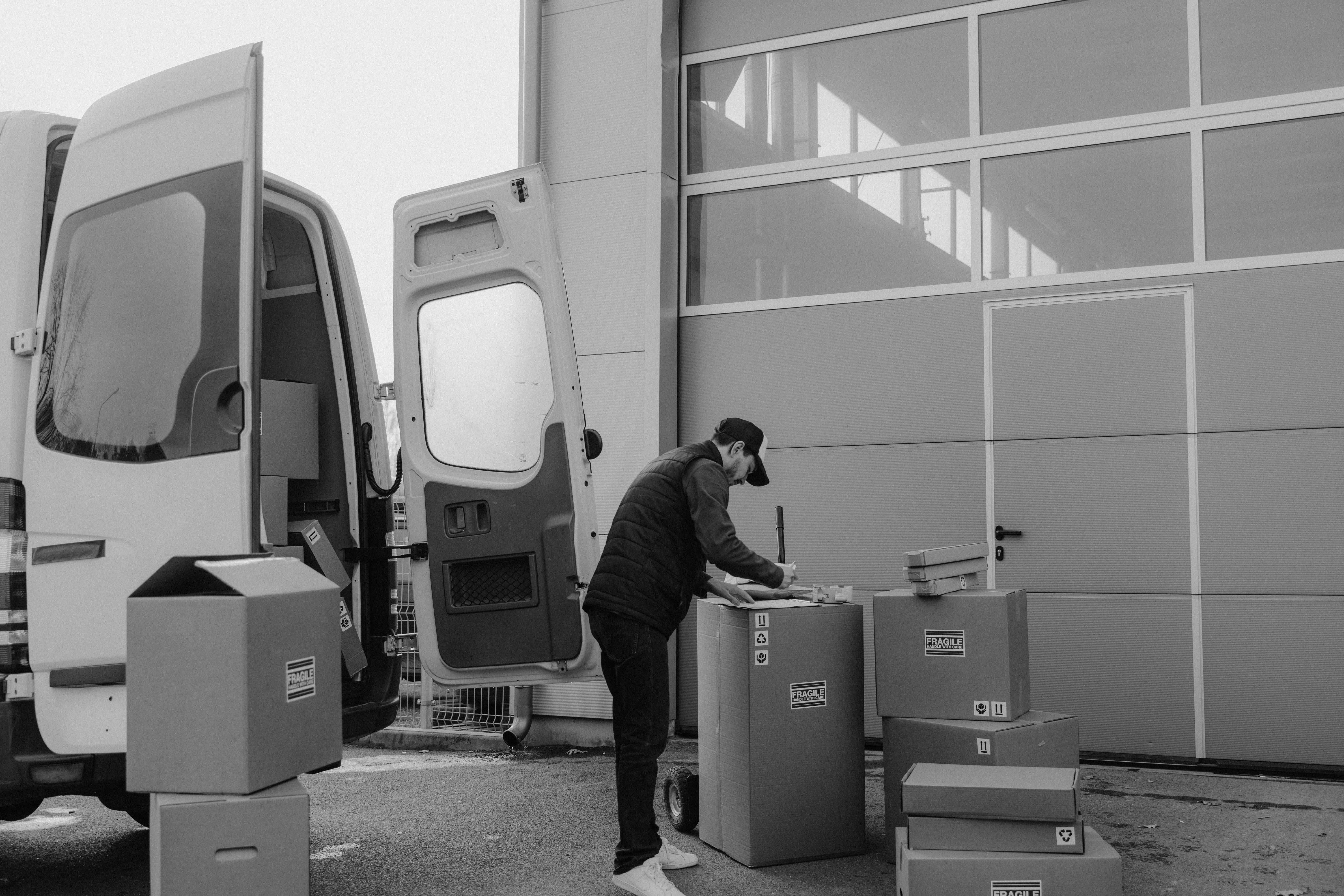 delivery man writing on a carton box