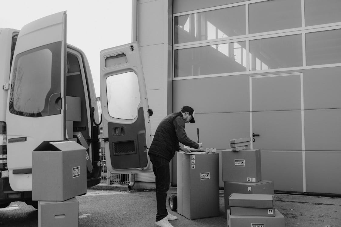 Delivery Man writing on a Carton Box