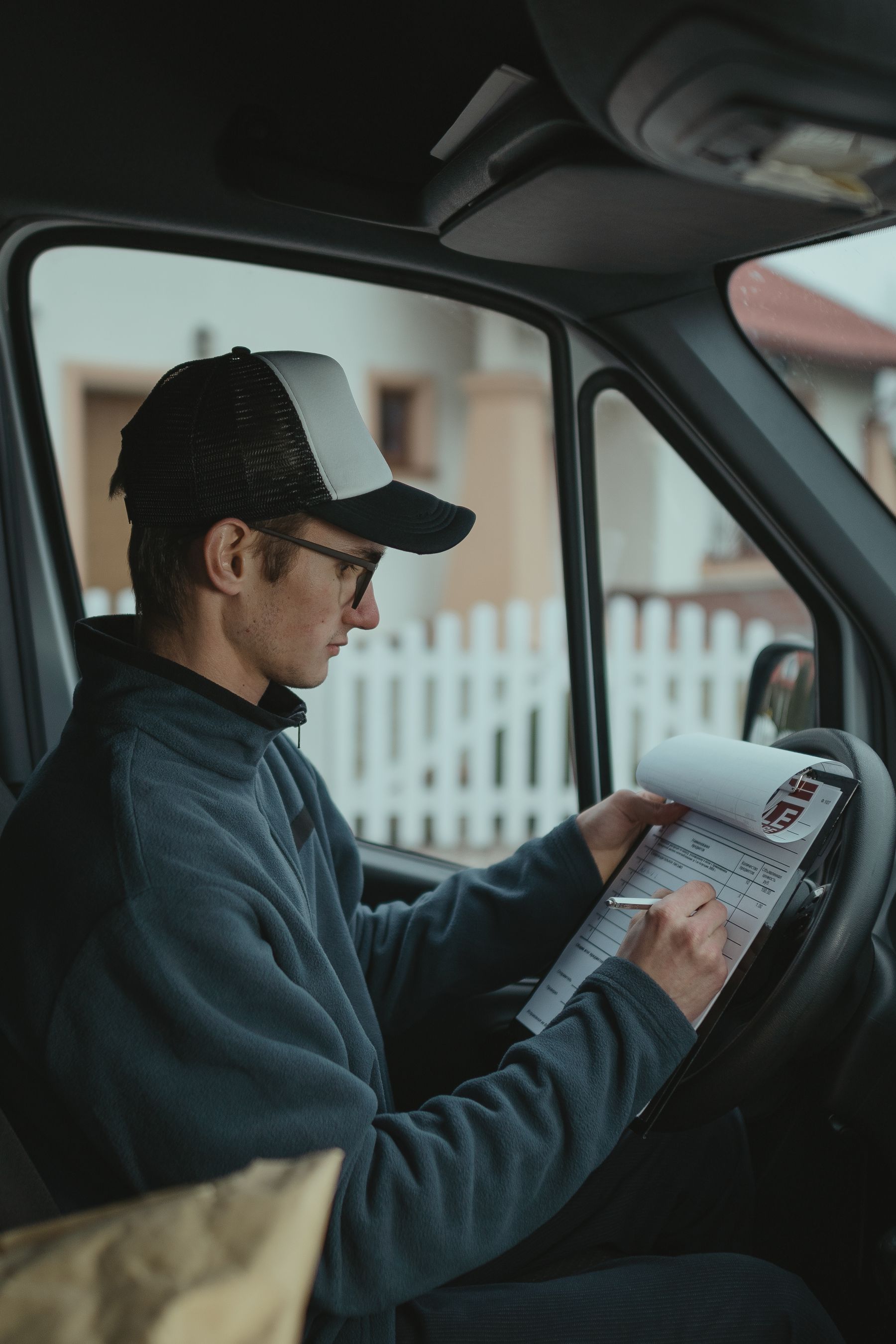 Transportation worker reviewing shipping records inside a commercial vehicle