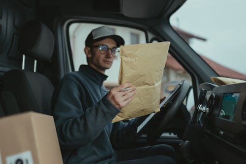 Free Delivery Man looking at a Parcel  Stock Photo