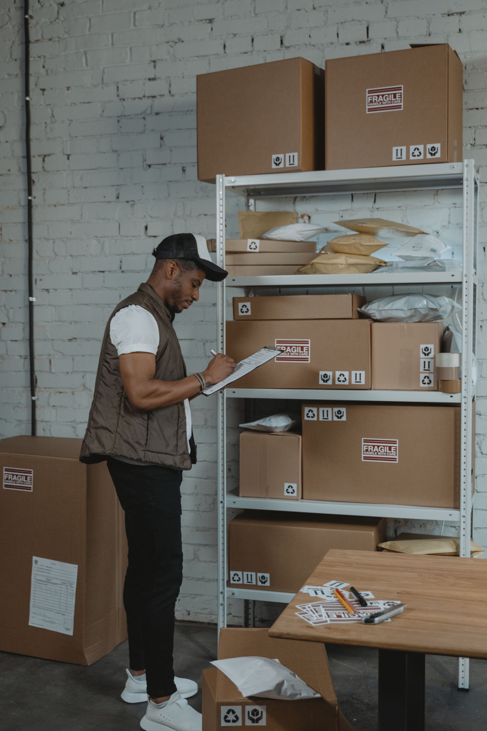 Warehouse worker writing shipping details on a clipboard