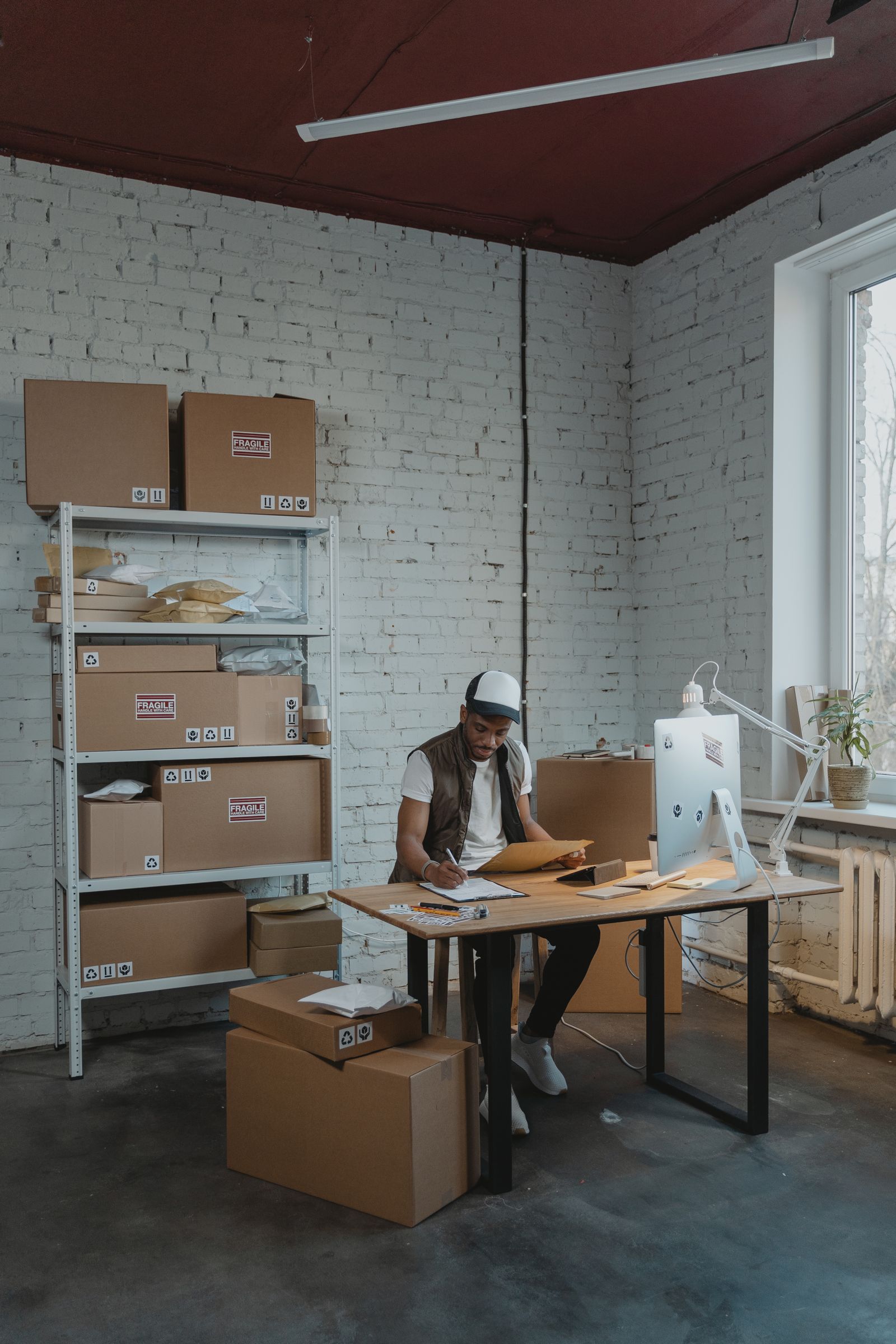 Worker organizing packages inside a small warehouse workspace