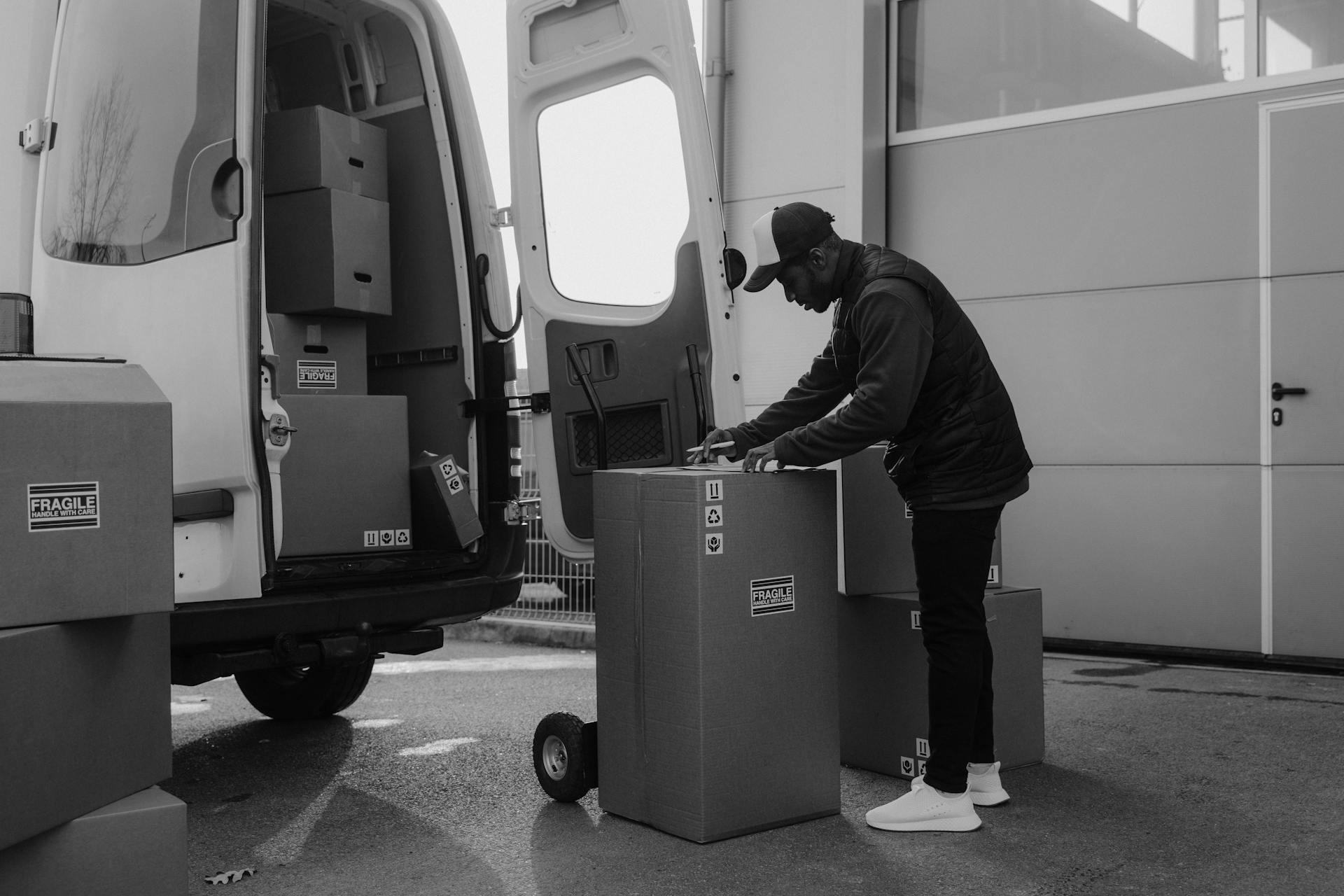 Delivery Man standing beside a Carton Box