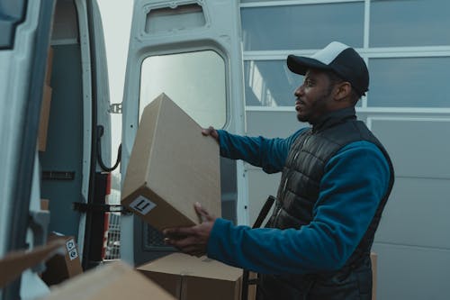 Free Delivery Man carrying a Package Stock Photo