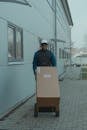 Delivery Man pushing a Trolley with Carton Boxes