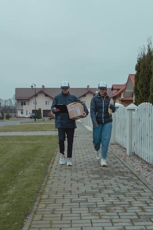 Man and Woman Carrying Packages Walking on the Sidewalk