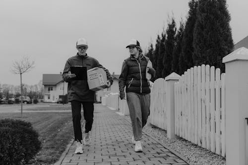 Man and Woman in Jackets Delivering Packages