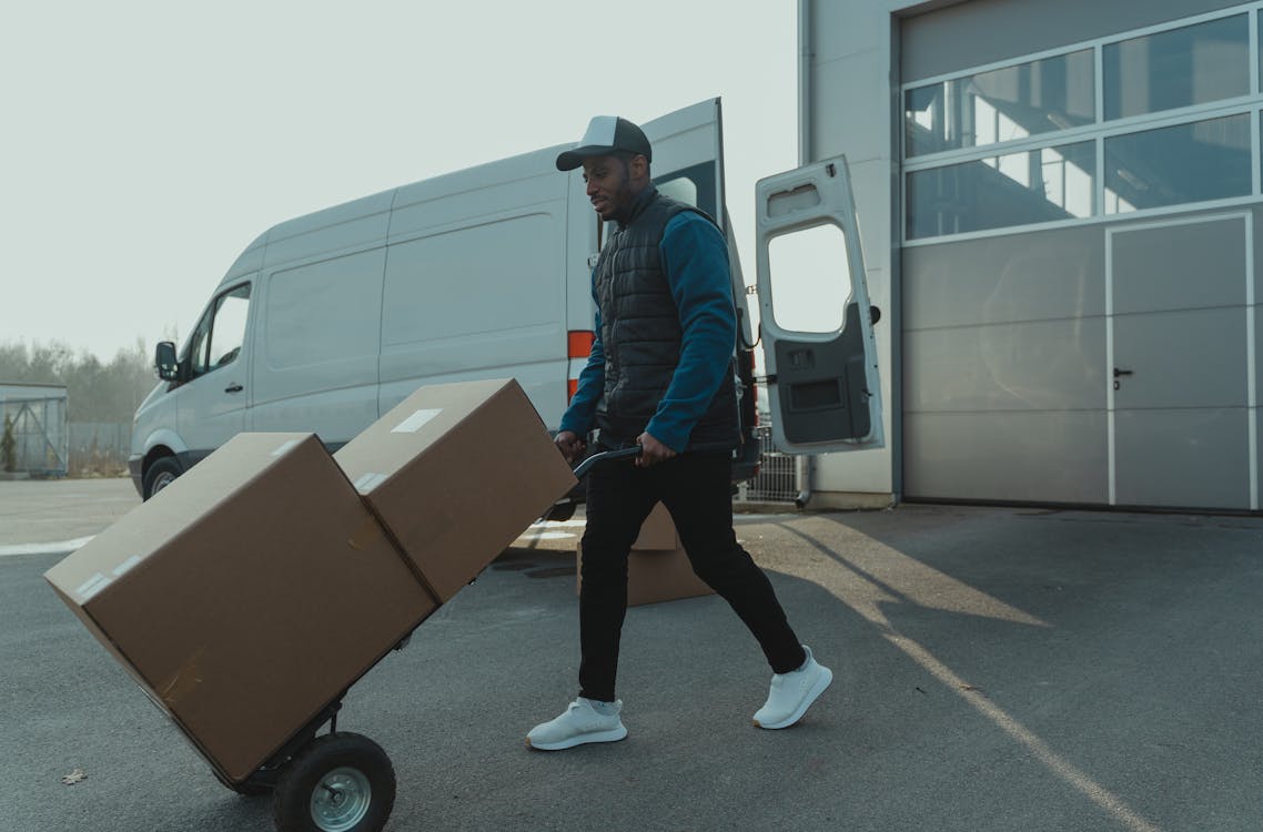 A trolley loaded with boxes being pushed by a person