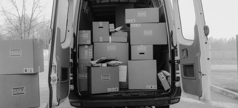 Cardboard moving boxes inside an open van.
