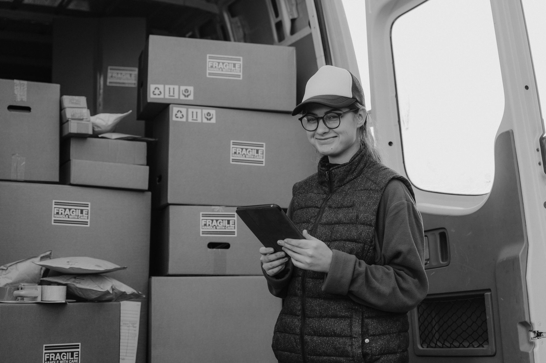 갤럭시폰 저장공간 부족 해결: 내장 및 SD카드 효율적 관리 팁 6 A delivery woman holding a tablet stands next to van full of parcels.