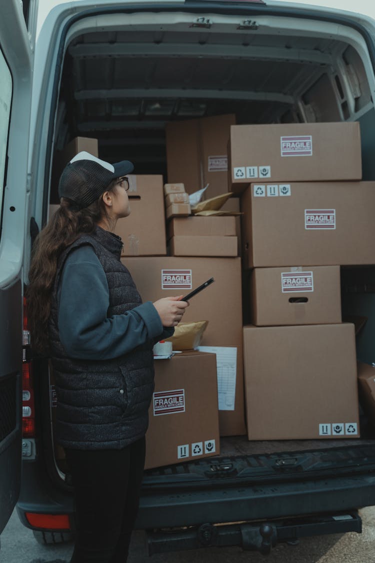 ]A Woman Checking A Van Delivery Contents