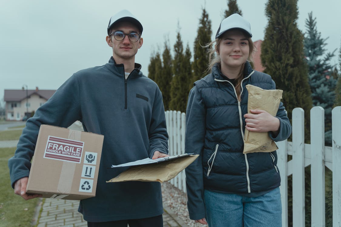 A Man and a Woman Holding Delivery Packages