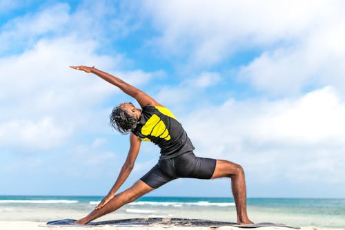 Free Person Stretching on Beach Shore Stock Photo