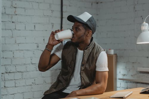 Man drinking Coffee on a Disposable Cup 
