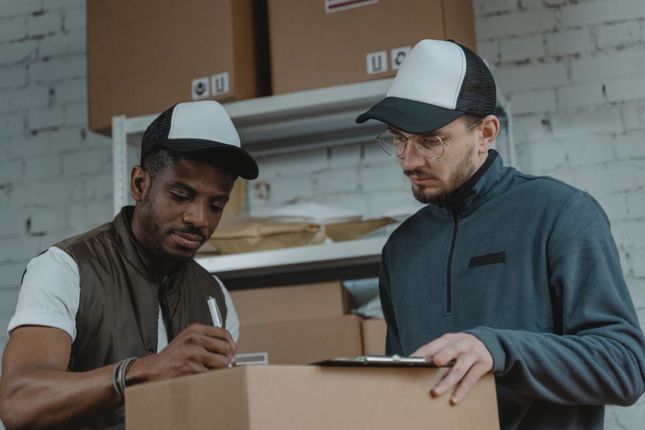 Two couriers working together to process deliveries in a warehouse setting.