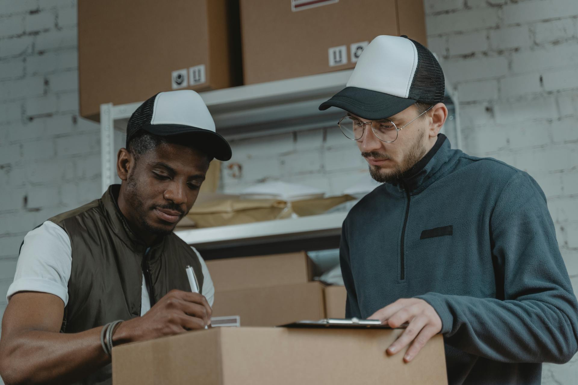 Two couriers working together to process deliveries in a warehouse setting.