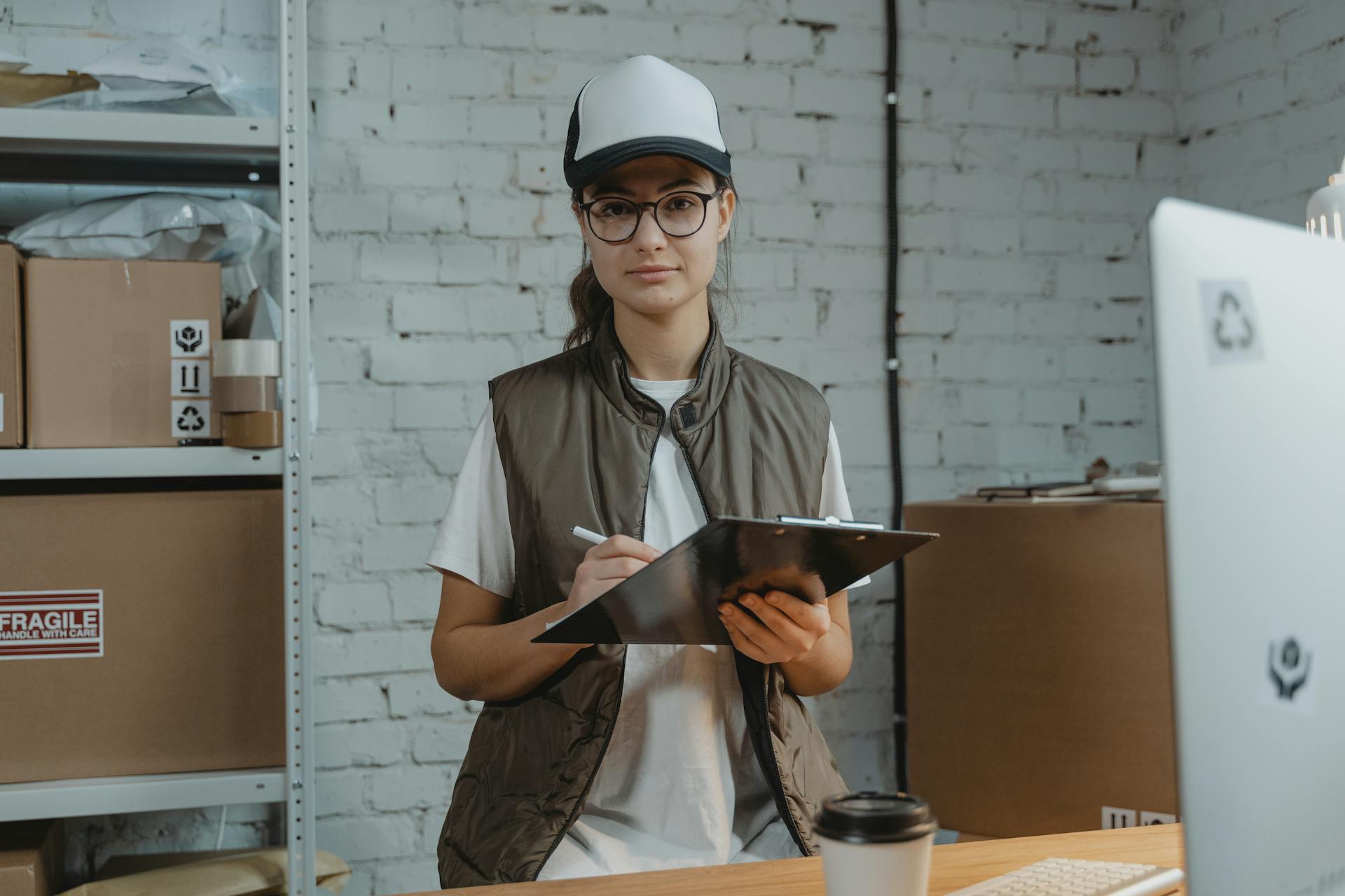 Young woman with clipboard in a warehouse, managing inventory with precision.