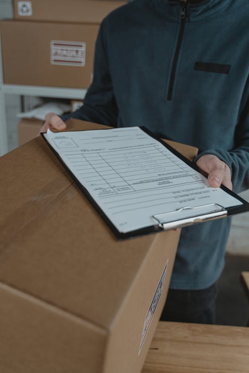 Free Clipboard with Data on Top of Box  Stock Photo